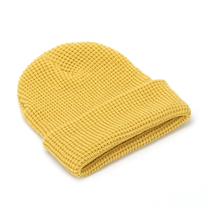 Detailed close-up of the ginger yellow waffle knit texture on a thick beanie hat