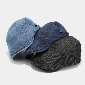 Detailed view of denim patchwork berets in blue and black with adjustable metal buckles