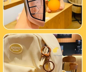 Detail of orange capybara keychain attached to a backpack zipper and car key fob
