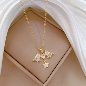 Detailed view of gold angel wing necklace with heart zircon and star pendant accessory
