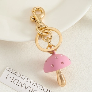 Macro detail van roze kristallen paddenstoel sleutelhanger met gouden sluiting