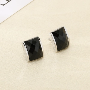 Macro shot of faceted black glass earrings featuring silver-plated textured metal edges
