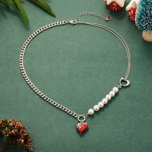 Asymmetric pearl and silver chain necklace with red heart pendant in festive setting