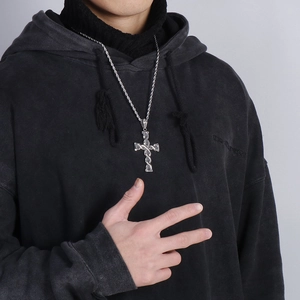 Silver cross pendant necklace on a black hoodie model with textured twisted link chain