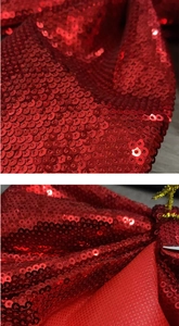 Macro shot of red sequin Christmas bow detailing the texture and glittery surface