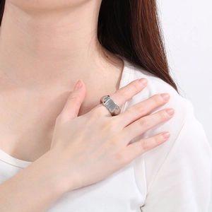 Close-up of a silver wide irregular geometric ring with a molten metal texture finish