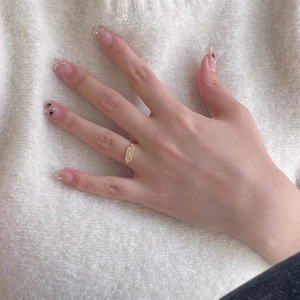 Detail of a vintage gold oval signet ring worn over a soft cream knitted sweater texture
