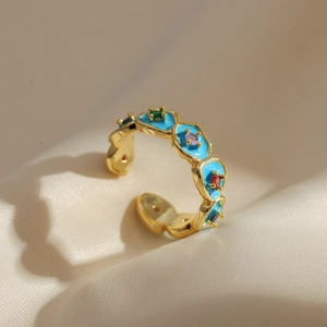 Golden chain link open ring with bright blue enamel and colorful gemstones on silk