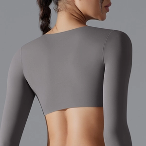 Vista posteriore del crop top yoga grigio scuro a maniche lunghe in tessuto elastico senza cuciture