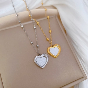 Close-up of gold and silver heart necklaces with shell inlay and small crystal detail