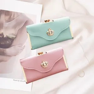 Detail of mint green and dusty pink long wallets with gold crown and heart clasp closure