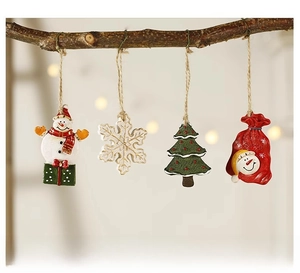 Detailed view of four resin Christmas ornaments including snowman and tree on rustic branches