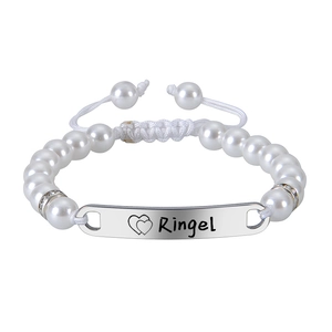 Détail du bracelet en perles réglable avec plaque métallique rectangulaire gravée