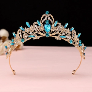 Detailed close-up of baroque golden crown with sky blue crystals and white rhinestones