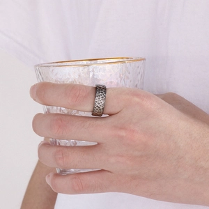 Close-up of a vintage 8mm grooved titanium steel ring with a hammered texture on hand