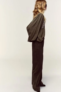 Side view of dark olive linen blouse with white embroidery and puff sleeves