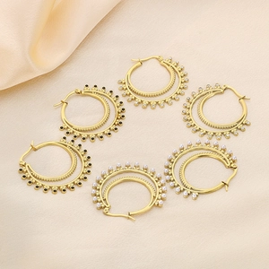 Detail of vintage gold layered hoop earrings with black beads, crystals, and pearls on silk