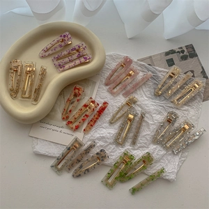 Colorful acrylic duckbill hair clips in rectangular and waterdrop shapes on a tray