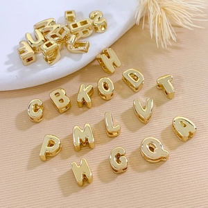 Detailed macro shot of 18K gold-plated DIY alphabet metal beads for jewelry making
