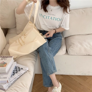Detail der cremefarbenen Bebe-Stofftasche im koreanischen Stil mit modischem Sommeroutfit