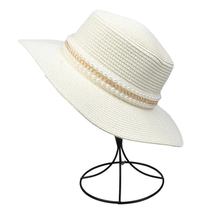 Detail of woven straw hat featuring double-row pearl trim and gold chain decoration