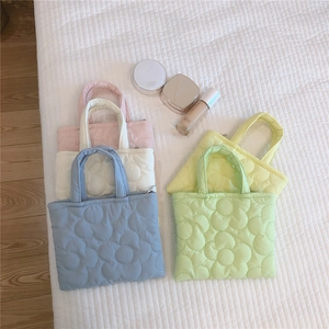 Dettaglio di mini borse trapuntate a fiori in colori pastello con zip resistente