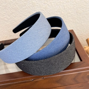 Gros plan détaillé de trois serre-têtes larges en denim bleu et noir avec fils argentés