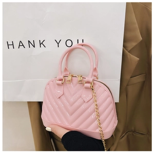 Detailed view of pink jelly shell bag with quilted V-patterns and gold chain strap