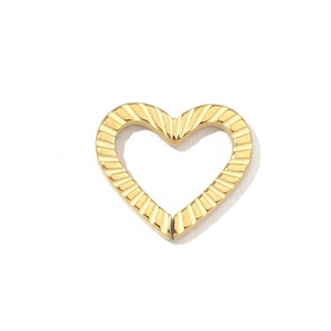 Detailed view of heart-shaped golden pendant with vertical striped metal texture