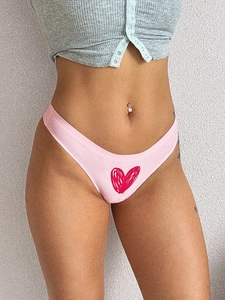 Detail of light pink seamless thong featuring a red hand-drawn heart for fitness