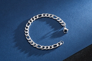Macro shot of silver Figaro titanium steel chain bracelet with secure lobster clasp
