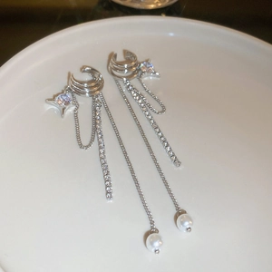 Detail of silver tassel ear cuff featuring sparkling zircons and a star pendant with pearls