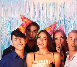 Vibrant party scene with silver and blue foil fringe curtains and colorful party hats