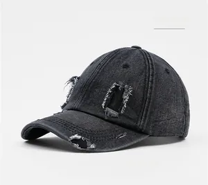 Macro detail of distressed black denim baseball cap with vintage frayed holes and stitching