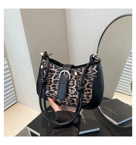 Detail of leopard print underarm bag with black leather trim and metal buckle