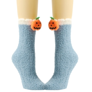 Detail von blauen Korallenfleece-Socken mit süßer orangefarbener 3D-Kürbis-Puppenverzierung