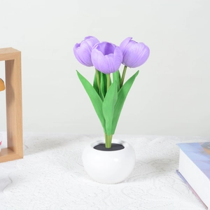 Detail of purple LED tulip night light in white ceramic pot on a lace tablecloth