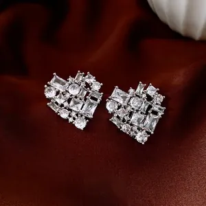 Silver needle heart earrings with sparkling cubic zirconia on brown silk backdrop