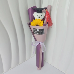 Detail of graduation bear bouquet with sunflower and purple gift wrapping paper