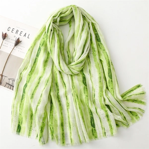 Detail of light green and white striped scarf with silver glitter and fringe edges