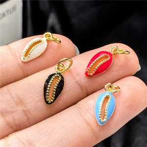 Detail of shell-shaped alloy pendants in four colors for DIY jewelry making