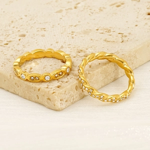 18K gold plated stainless steel rings with sparkling cubic zirconia on a stone surface