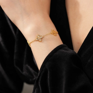 Close-up of a gold zircon flower bracelet on a model wrist against black velvet