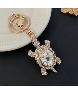 Detailed view of turtle keychain with sparkling crystals and golden lobster clasp