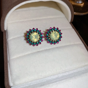 Macro shot of vintage floral stud earrings featuring colorful crystals in a jewelry box
