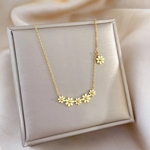 Minimalist gold titanium steel necklace featuring six daisy flowers on jewelry display box