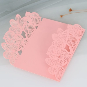 Macro view of laser-cut pink floral invitation cover with intricate hollow rose patterns