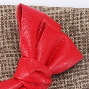 Detailed close-up showing the texture of a luxury red PU leather bow hair clip
