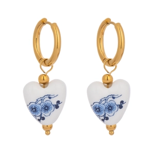 Detail of vintage heart-shaped ceramic drop earrings with blue floral patterns