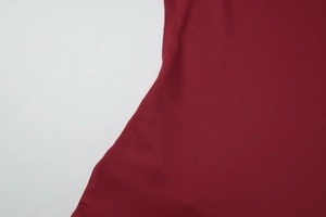 Detailed macro view of burgundy knitted fabric texture and fine fiber craftsmanship